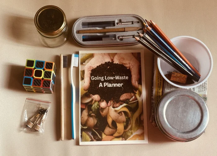 Low waste planner sorrounded by low waste swaps and reused plastic to show the most sustainable item is what you have